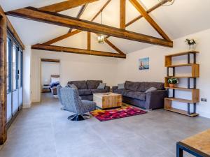 a living room with two couches and a table at Skylark Barn-Uk31354 in Swaffham