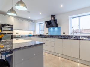 a kitchen with white cabinets and granite counter tops at Skylark Barn-Uk31354 in Swaffham