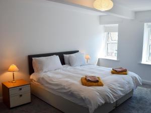a bedroom with a large bed with two towels on it at Alice Cottage in Embleton