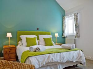 a bedroom with a large bed with green walls at The Cottage in Cheltenham