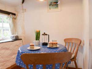 ein Tisch mit einer blauen, gepunkteten Tischdecke, auf dem Cupcakes stehen in der Unterkunft Scrumpy Cottage in Bodmin