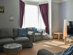a living room with a couch and a tv at Zack's Seaside Stay in Bridlington