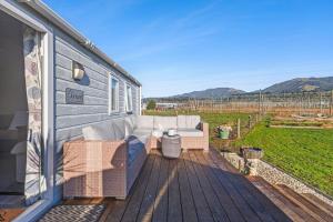 a patio with a couch and chairs on a deck at Thorndale Country Escape in Umukuri