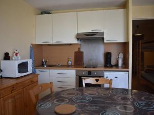 a kitchen with white cabinets and a table with a microwave at Agréable T2 cabine à Font-Romeu pour 6 personnes - FR-1-580-134 in Font Romeu Odeillo Via