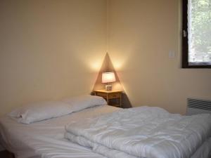 a bedroom with a bed and a table with a lamp at Agréable T2 cabine à Font-Romeu pour 6 personnes - FR-1-580-134 in Font Romeu Odeillo Via
