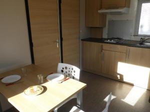 a small kitchen with a table and a table and chairs at Chalet de 22m² avec Terrasse pour 4 personnes - API-1-52-414 in Saint-Sornin