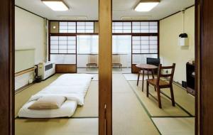 a room with a bed and a table and a chair at 北のくらし研究所 in Rokugō