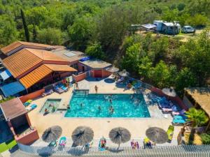an overhead view of a large swimming pool with umbrellas at Mobil-home avec terrasse pour 4 personnes - API-1-52-528 in Le Boulou