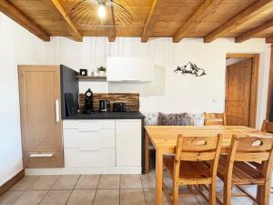 a kitchen with a table and chairs in a room at Appartement cosy au Cernix près des pistes, 2 chambres, terrasse - FR-1-505-233 in Crest-Voland