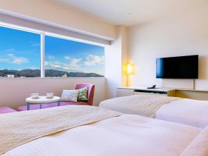 a hotel room with two beds and a window at Hotel Nikko Himeji in Himeji