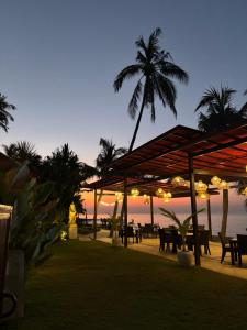 a restaurant on the beach with palm trees and lights at Villa Ganesha Penuktukan in Tejakula