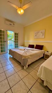 a bedroom with a large bed and a ceiling fan at Grand Maré Hotel in Peruíbe