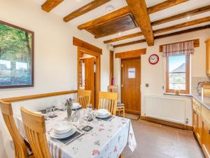 a kitchen and dining room with a table and chairs at The Lodge in Lydney