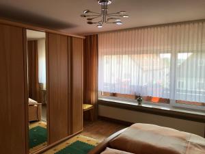 a bedroom with a window and a bed and a chandelier at Freistehendes Ferienhaus Mit Südbalkon in Marktrodach