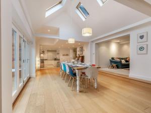 a dining room and living room with a table and chairs at Tall Trees in Whitstable