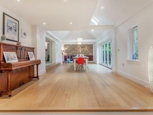 an empty living room with a piano and a table at Tall Trees in Whitstable +30 photos