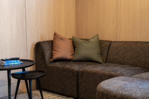 eine Couch mit Kissen darauf in einem Wohnzimmer in der Unterkunft Apres Peak - Queenstown Holiday Home in Frankton