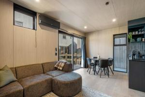 ein Wohnzimmer mit Sofa und Tisch in der Unterkunft Apres Peak - Queenstown Holiday Home in Frankton