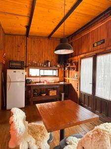 a kitchen with wooden walls and a table and a refrigerator at Aerohouse in Posadas