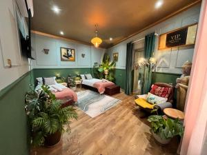 a living room with two beds and plants in it at Apartamenty z Duszą in Radom