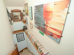 a staircase with a painting on the wall at Wheal Trenwith Cottage in St Ives