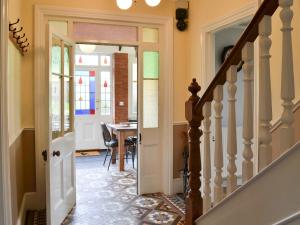 a hallway with a staircase leading to a dining room at Cranford House in Woolfardisworthy