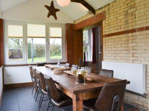 a dining room with a wooden table and chairs at Cranford House in Woolfardisworthy