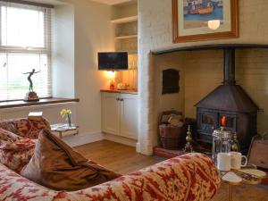 a living room with a couch and a fireplace at Cranford House in Woolfardisworthy