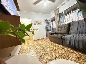 a living room with a couch and a table at Pé na Areia Praia da Guilhermina VI in Praia Grande