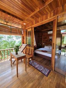 um quarto com uma cama e uma mesa num deque em Jade Mountain Bungalow - Sea Breeze - Infinity Pool em Duong Dong mais 29 fotografias