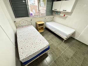 a small room with two beds and a window at Pé na Areia Praia da Mirim in Samaritá +36 photos