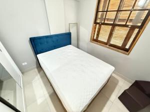 a small bed in a room with a window at Pé na Areia Praia do Gonzaguinha II in São Vicente