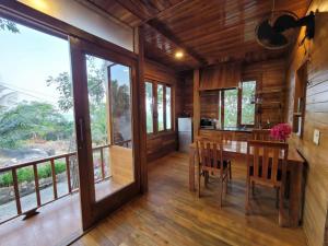 uma sala de jantar com uma mesa e algumas janelas em Jade Mountain Bungalow - Sea Breeze - Infinity Pool em Duong Dong