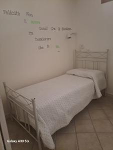 Una cama en una habitación con palabras en la pared en Centrale in Tropea, en Tropea
