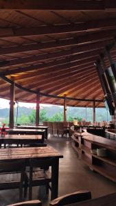 un ristorante con tavoli e sedie in legno con le montagne sullo sfondo di Làng Nhỏ - Hồ Láng Nhớt Resort with Nature Life a Nha Trang