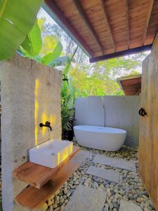 un bagno con vasca e lavandino di Làng Nhỏ - Hồ Láng Nhớt Resort with Nature Life a Nha Trang