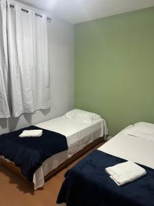 due letti in una stanza con pareti bianche e una finestra di Desfrutar Encanto a San Paolo Altre 12 foto