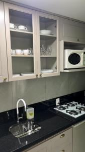 un bancone da cucina con lavello e microonde di Desfrutar Encanto a San Paolo