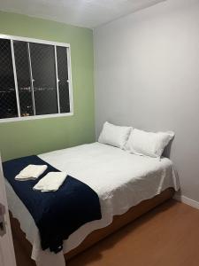 una camera da letto con un letto con due asciugamani sopra di Desfrutar Encanto a San Paolo