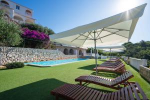 a group of chairs and umbrellas next to a pool at Apartments in Potocnica - Insel Pag 47657 in Potocnica