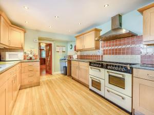 a large kitchen with wooden cabinets and appliances at Greenbank in Keswick