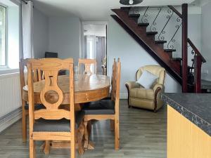 a dining room with a wooden table and chairs at Elder Cottage in Bridgend