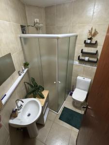 a bathroom with a shower and a toilet and a sink at The Village Real in Paraty