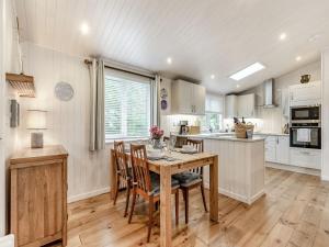 a kitchen with a wooden table and chairs at Rosemary Lodge in Willington