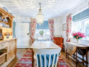 una cucina con un tavolo, un divano e un lampadario di Hero Cottage a Holt