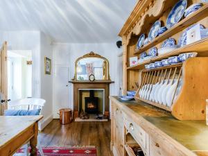 un soggiorno con camino, tavolo e sedie di Hero Cottage a Holt