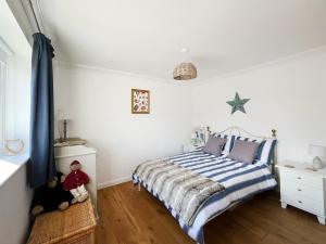 a bedroom with a bed with a blue and white striped blanket at Sea Breeze in Pagham