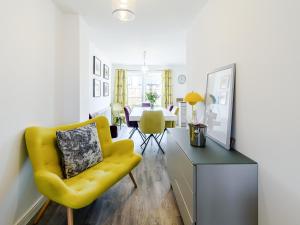 ein Wohnzimmer mit einem gelben Stuhl und einem Tisch in der Unterkunft Coastal Retreat in Amble