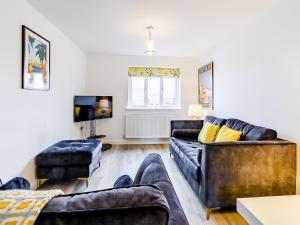 ein Wohnzimmer mit zwei Sofas und einem Fernseher in der Unterkunft Coastal Retreat in Amble