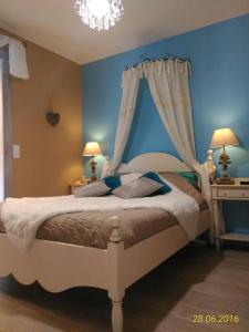 ein Schlafzimmer mit einem großen Bett mit blauen Wänden in der Unterkunft Villa Lescala in Blaye
